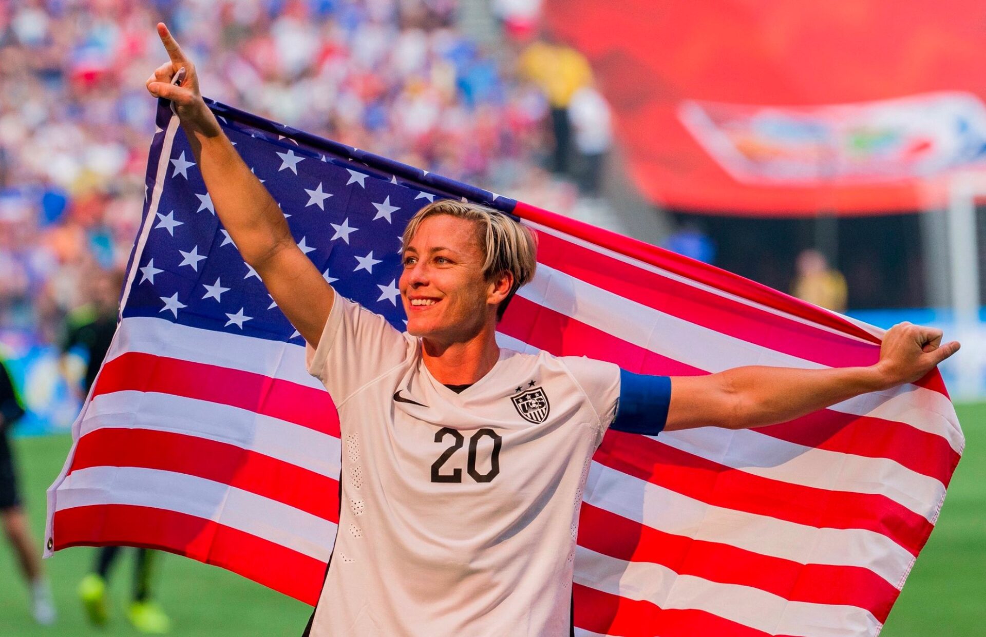 Abby Wambach is pictured here holding the America Flag as she celebrates the women's soccer team win.