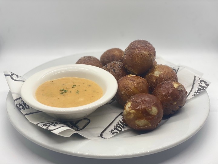 This image depicts a plate of warm and soft pretzel nuggets that are served with our house made Sierra Nevada beer cheese sauce.